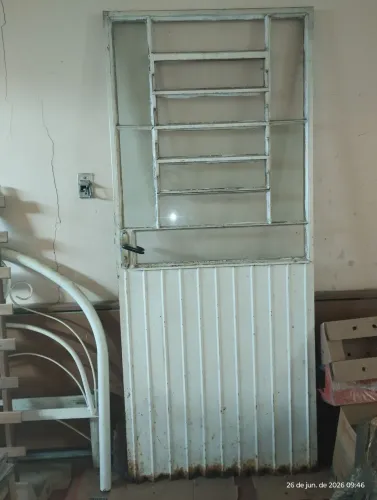 Porta de ferro com janela de vidro e veneziana em cima
