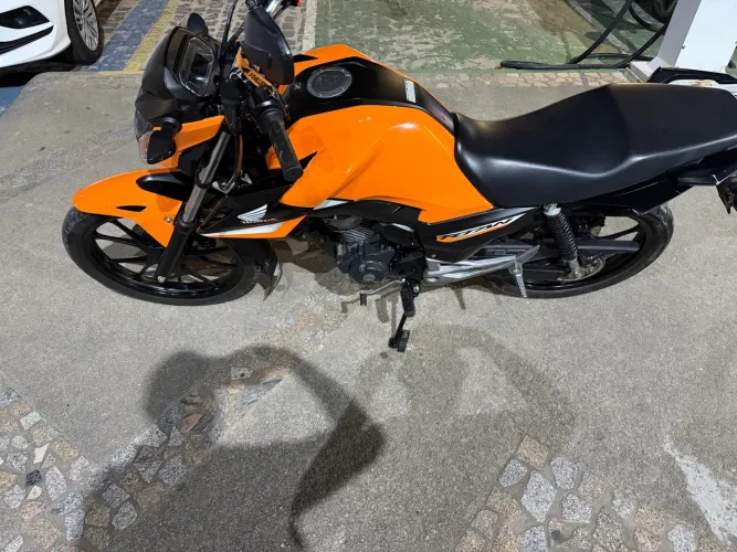 Honda CG Titan 160, ano 2025, na cor laranja, visual moderno e esportivo.