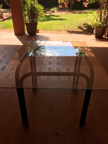 MESA COM ESTRUTURA TUBULAR METÁLICA E TAMPO DE VIDRO.   120 (c) X 95 (l) X 75 (h) cm