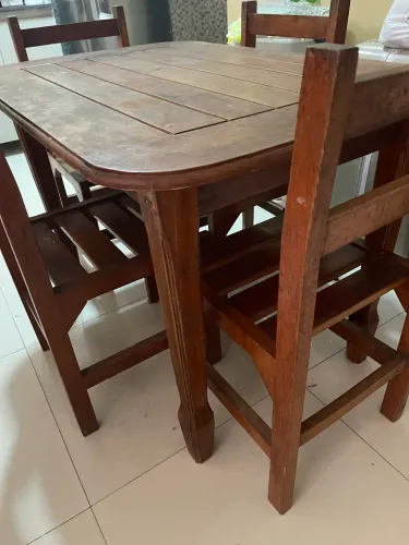Mesa de madeira com quatro cadeiras. 