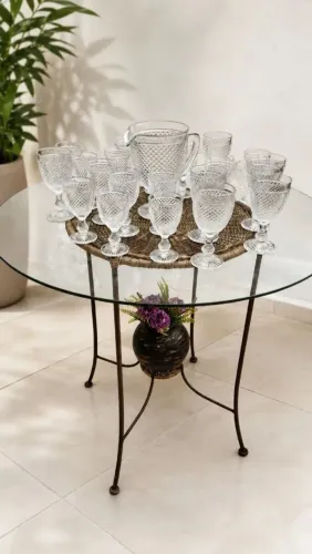 Mesa de vime com tampa de vidro e jarra e copos