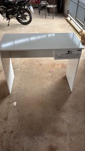 Mesa de escritório branca com gaveta e chave.