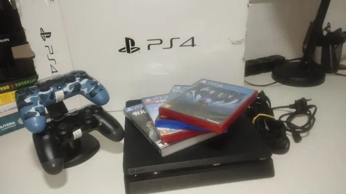 PS4 com caixa e jogos.
