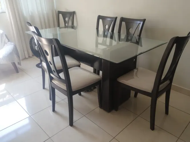 conjunto de sala de jantar composto por uma mesa retangular com tampo de vidro