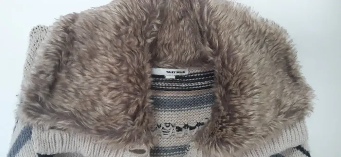 Casaco de tricô com detalhe na gola de pelúcia 