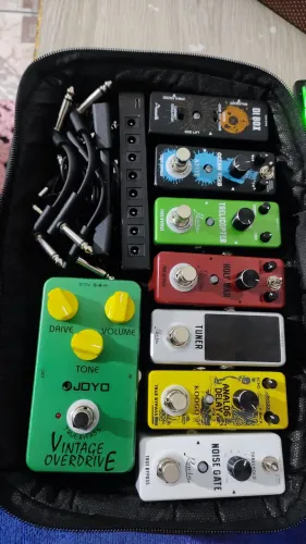 Pedais, fonte e cabos de guitarra.