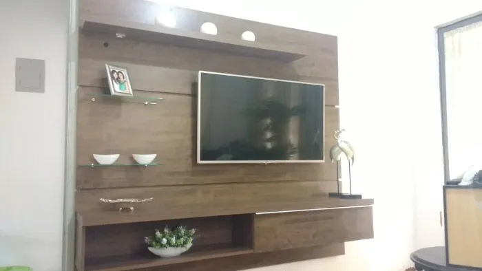 Painel de TV com nicho, porta basculante e iluminação.