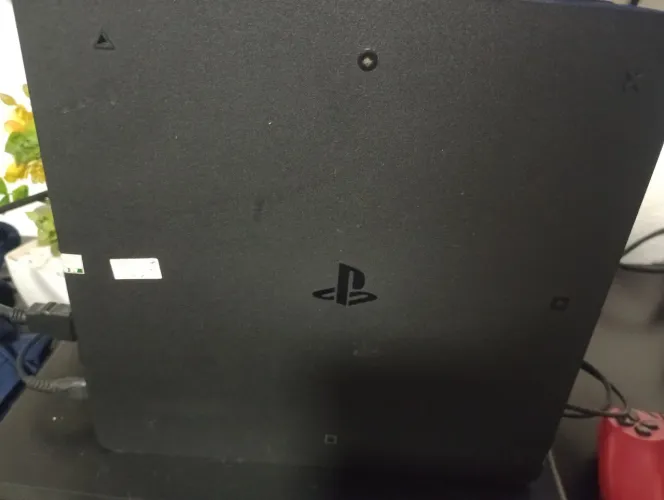PS4 em perfeito estado com dois controles e três jogos.