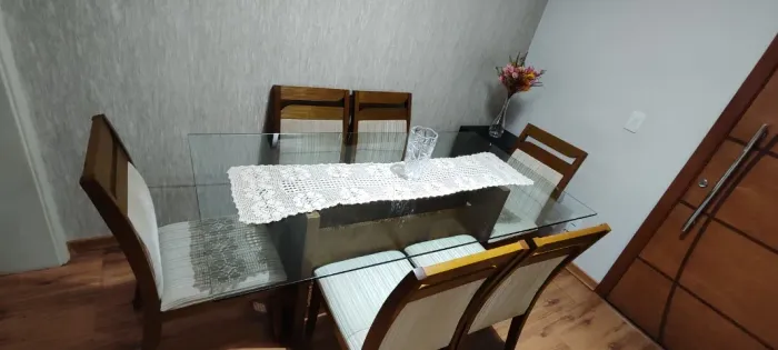 Mesa de jantar com tampo de vidro e 6 cadeiras estofadas em tecido