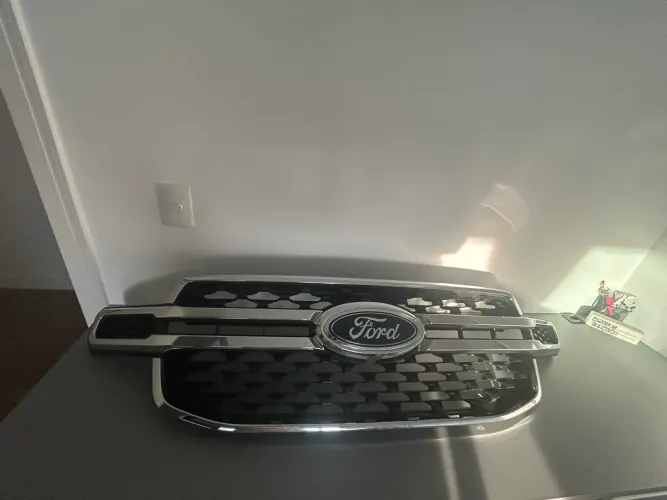 grade dianteira original da Ford, com acabamento em preto brilhante e frisos cromados.