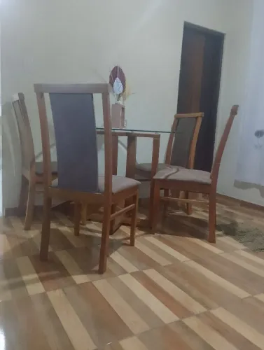 Mesa de cozinha acompanhada com quatro cadeiras de madeira macissa