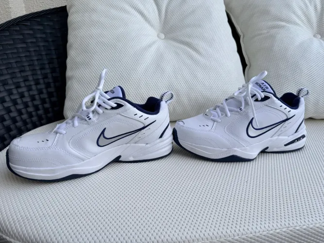 Nike Air Monarch IV na cor branca com detalhes em azul-marinho e prata.
