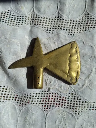 castão de bronze em forma de machado, frequentemente usado no topo de bengalas decorativa