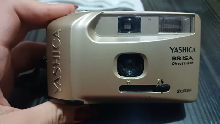 câmera analógica Yashica Brisa dourada, um modelo compacto dos anos 90.
