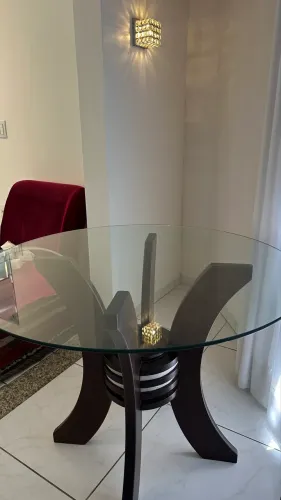 Mesa de vidro redonda com apoio em madeira