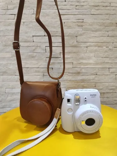 Fujifilm Instax Mini 9 branca acompanhada da capa original marrom.