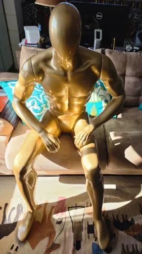 Manequim masculino dourado sentado