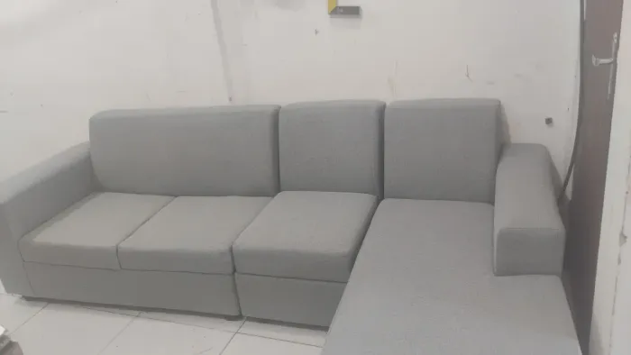 Sofá charse no tecido de linho acompanhado de pequenas almofadas como brinde .