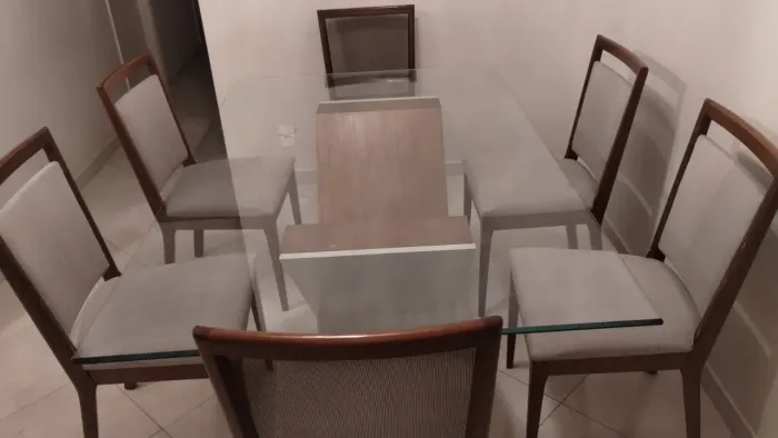 Mesa de vidro, com seis cadeiras conservadas.
