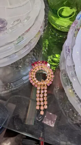 broche vintage em tom dourado com strass rosa e detalhes vermelhos no topo,