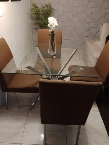 Mesa com quatro cadeiras de tampa de vidros e estrutura de inox