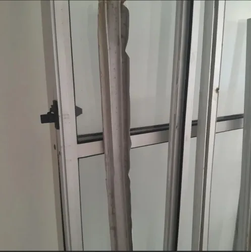 Porta em alumínio e vidro. Acompanha trilhos laterais e superior
