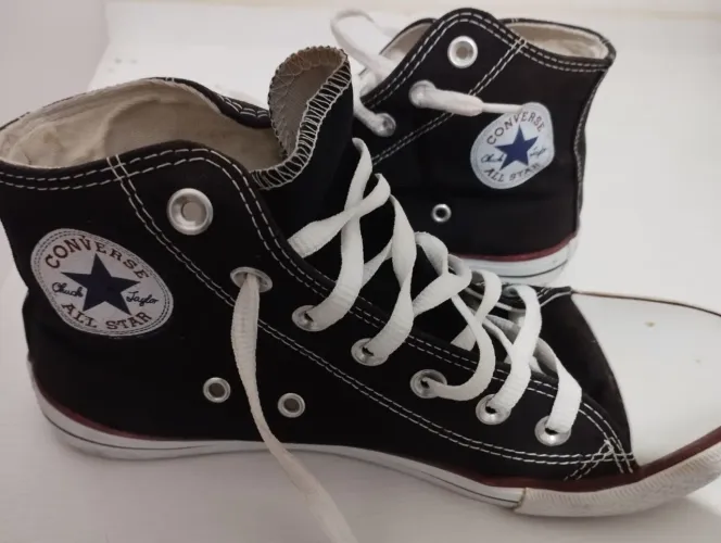 Tênis Converse All Star cano alto na cor preta, em excelente estado de conservação.