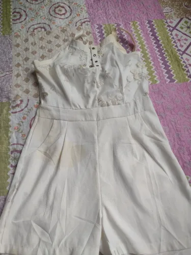 Macacão branco com detalhes em renda e defeito no fecho