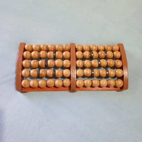 Massageador para os pés de madeira e imãs terapêuticos.