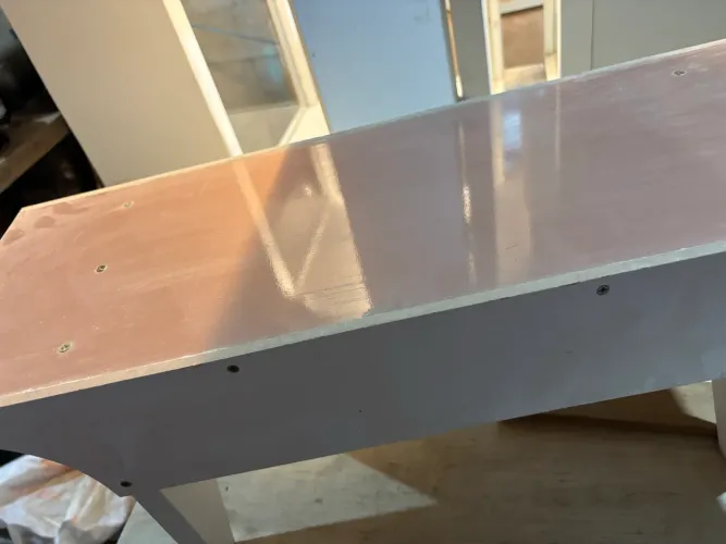 banqueta artesanal de madeira com acabamento branco na estrutura e tampo revestido de MDF