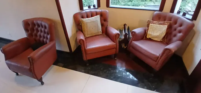 Três poltronas e um sofá de couro  legítimo.