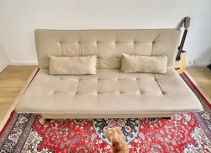 sofá cama bege com almofadas