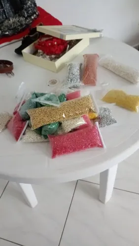 Pedrarias em liquidação de diferentes cores, vermelho, amarelo, verde e pérolas.