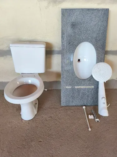 Vaso sanitário acoplado, chuveiro e pia.