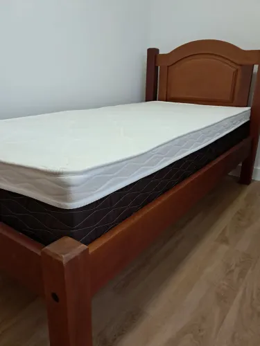 Cama de madeira maciça em mogno e colchão.