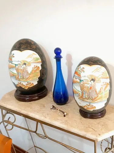 2 ovos de porcelana japonesa decorados base de madeira. Medem 50 e 40 cm de altura.