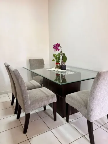 Linda mesa de vidro com 4 cadeiras almofadadas.