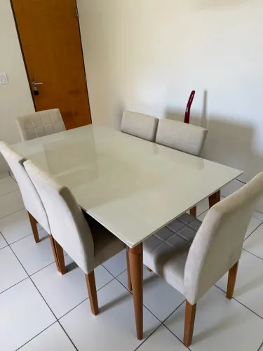 Mesa De vidro Laqueado com 6 cadeiras acolchoadas.