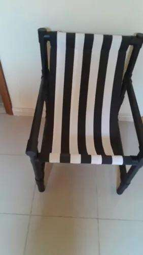 Poltrona feita com canos de pvc e pintada de preto com assento de tecido Dohler