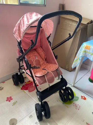 Carrinho de bebê rosa com detalhes florais