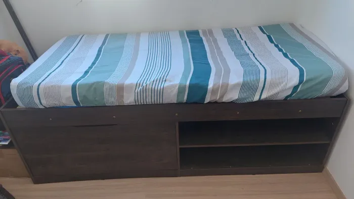 Cama de solteiro com colchão, cama possui sapateira.