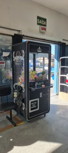 Grua de pelúcia faturando com 02 noteiros, 01 moedeiro e máquina de cartão. Placa verde.