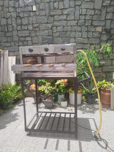 Churrasqueira a gás com espetos giratório.