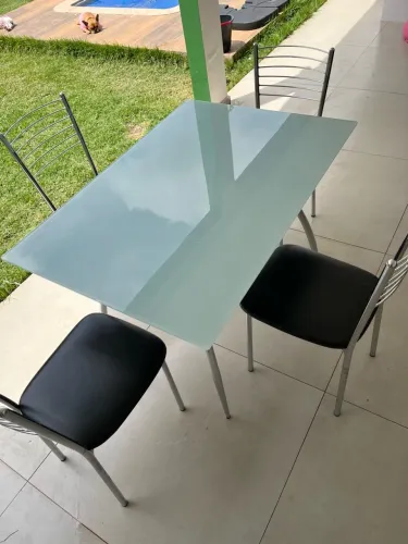 Mesa de vidro com quatro cadeiras inox