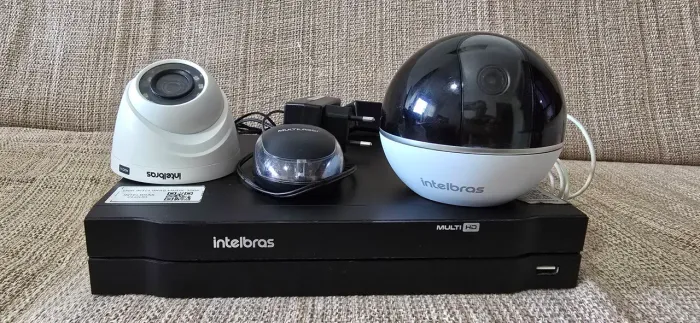 DVR Intelbras 4 canais com mouse, uma câmera HD e uma câmera Wi-Fi.