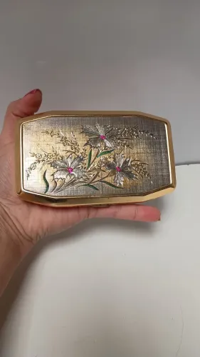 estojo musical vintage com acabamento dourado e tampa decorada com relevo floral