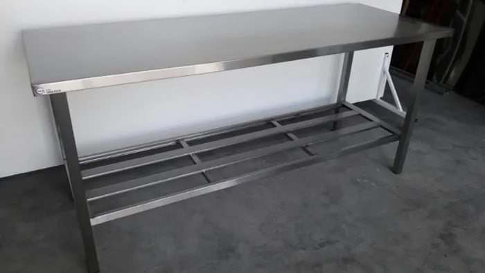 Mesa em aço inox com uma prateleira gradeada