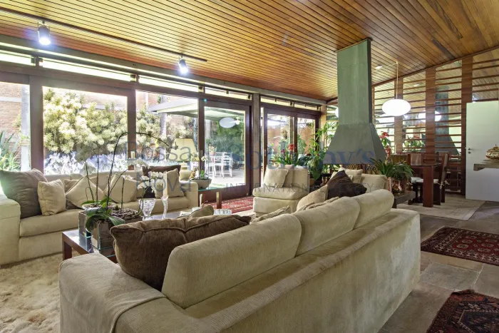 Casa com janelões e área externa com piscina e gramado no Cidade Jardim