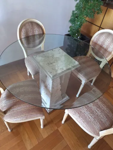 Mesa de jantar redonda com base de pedra e cadeiras