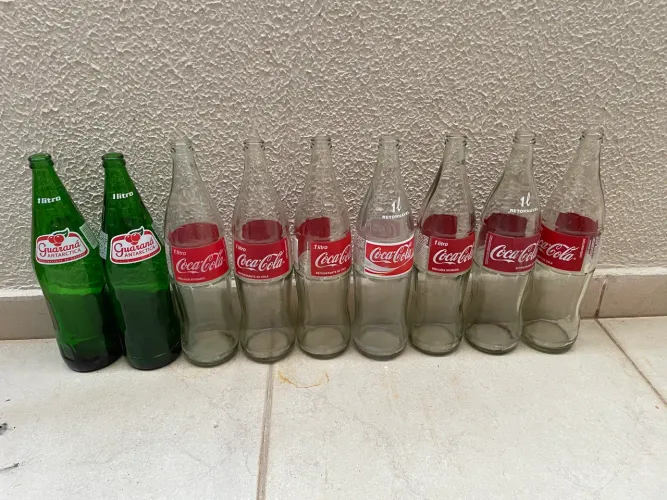 9 Vasilhames de Coca Coca e Guaraná de 1L vidro.